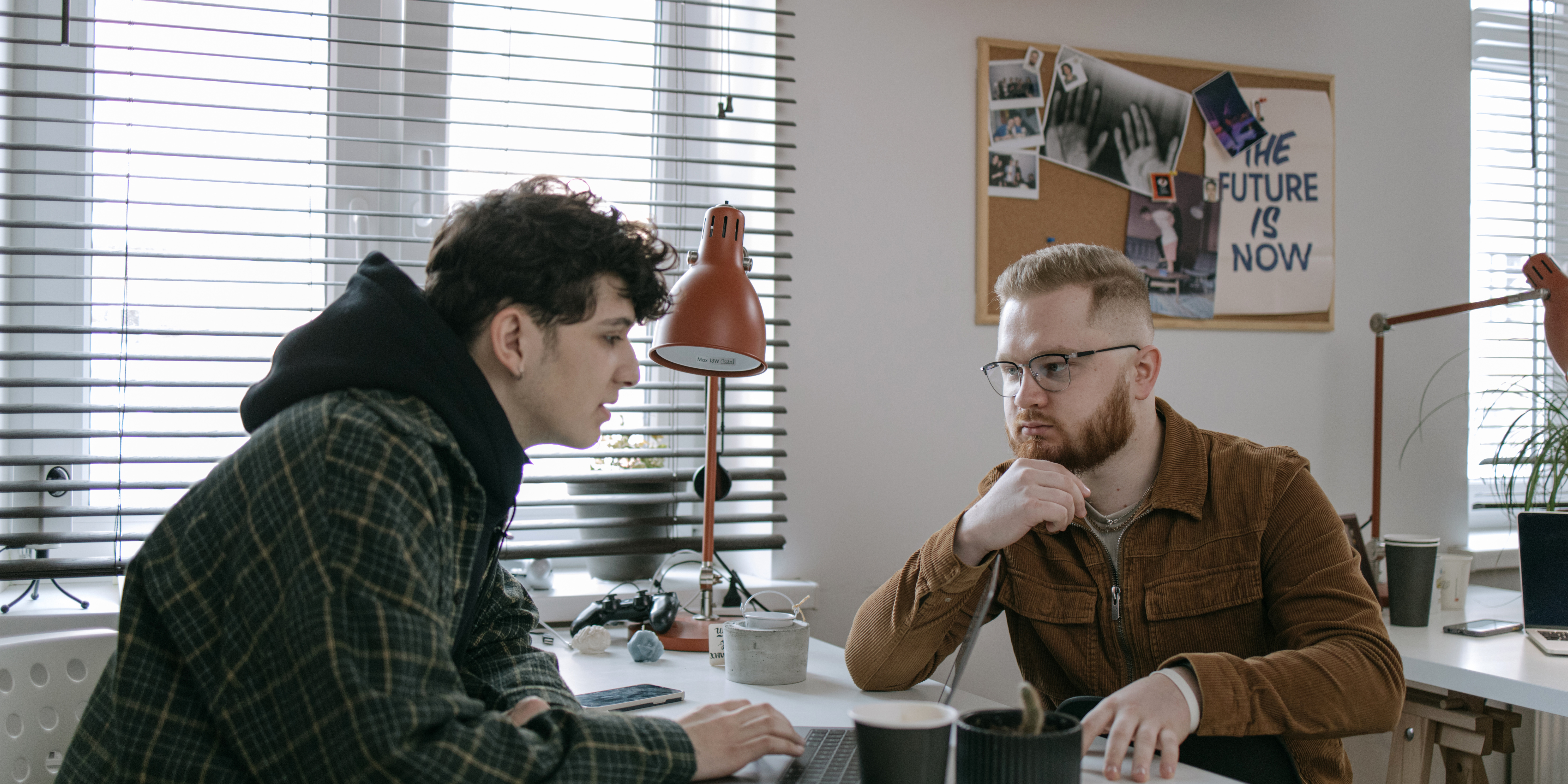A picture of two people in a office environment holding a serious conversation with eachother