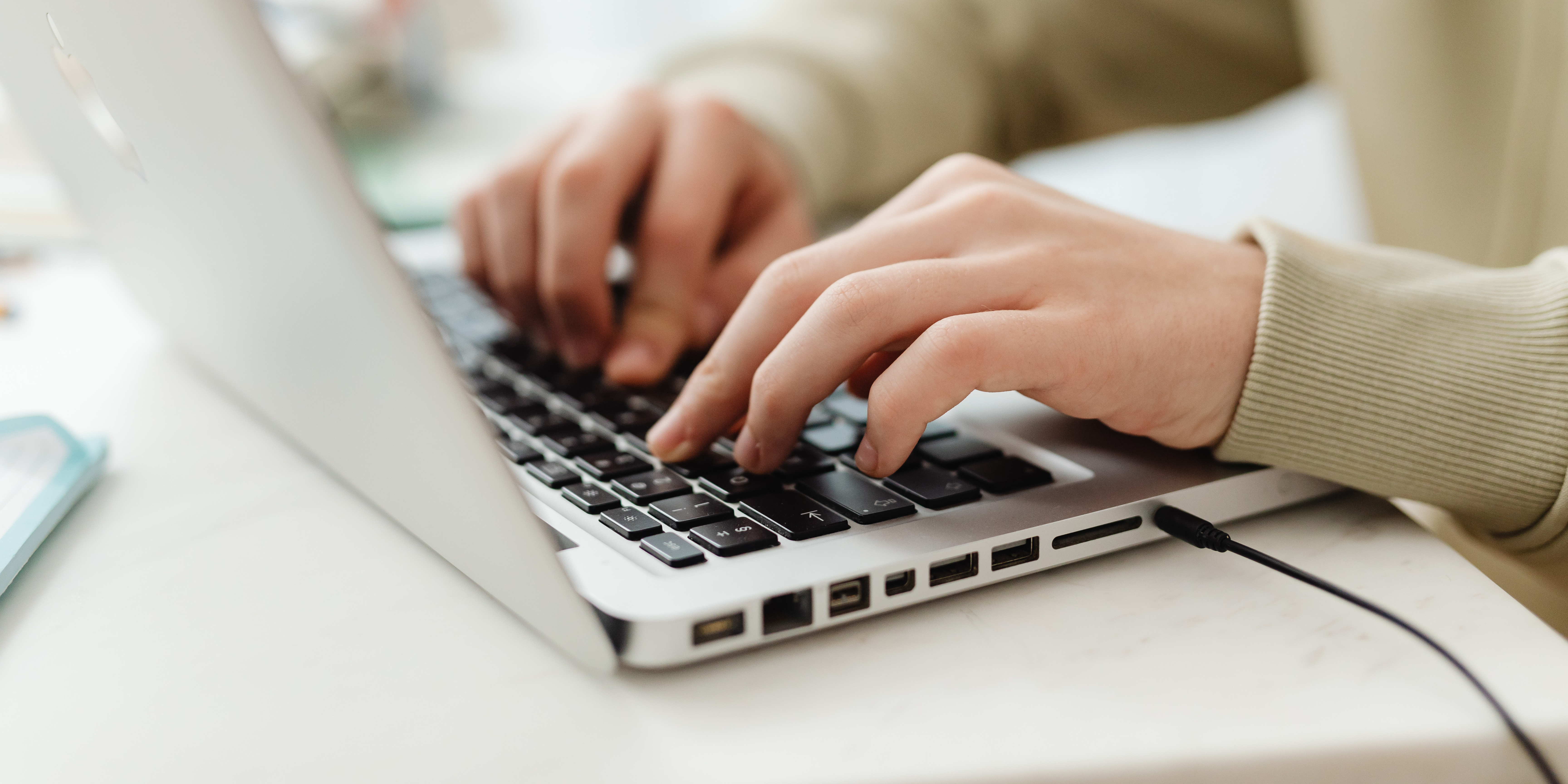 A person typing on there laptop.